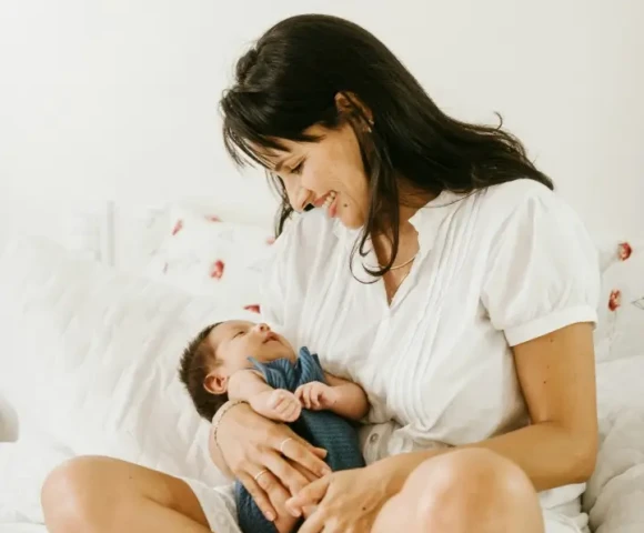 mother-holding-newborn-baby-sitting